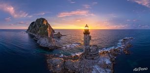 Rising sun rays through the lighthouse