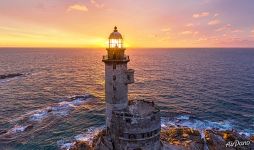 Rising sun rays through the lighthouse Rising sun rays through the lighthouse